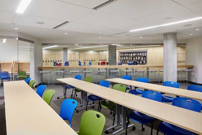 Aulas de una universidad con asientos coloridos y mesas de madera